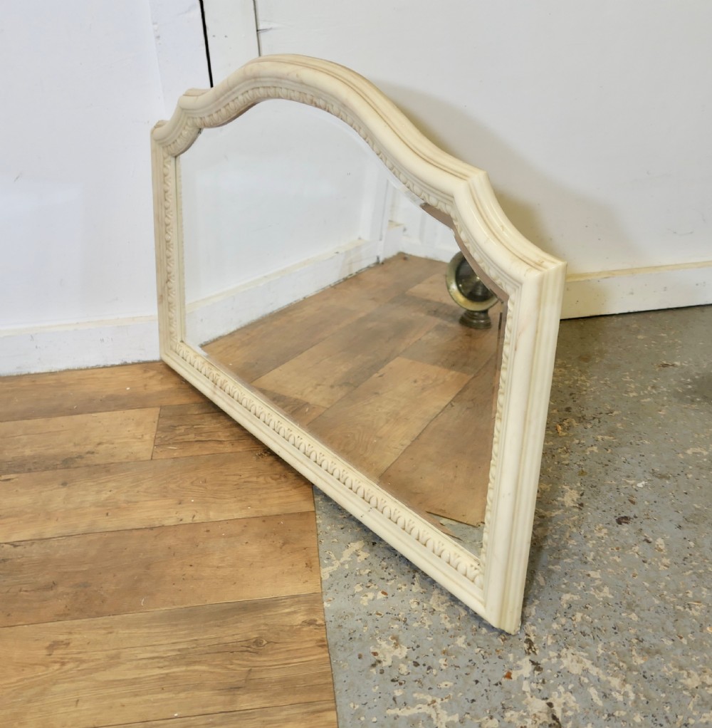 A large arched overmantel mirror featuring a cream simulated marble finish and carved egg-and-dart moulding along the interior rim. View VI
