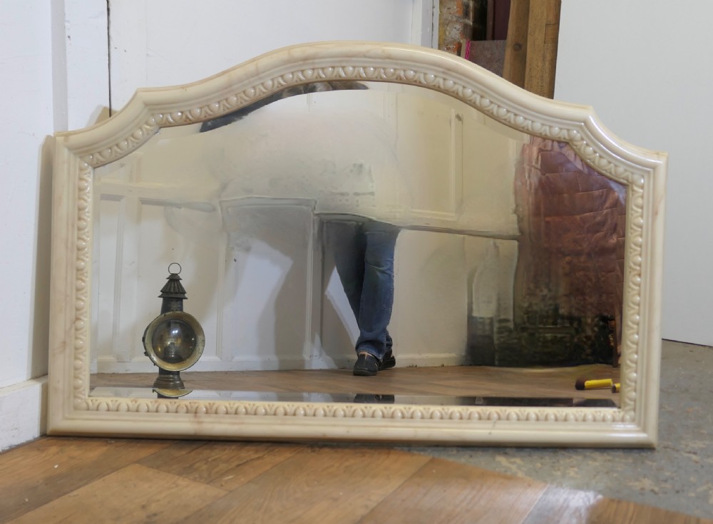 A large arched overmantel mirror featuring a cream simulated marble finish and carved egg-and-dart moulding along the interior rim. View VII