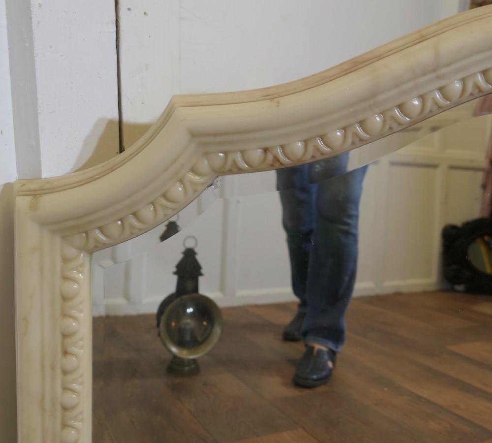 A large arched overmantel mirror featuring a cream simulated marble finish and carved egg-and-dart moulding along the interior rim. View VIII