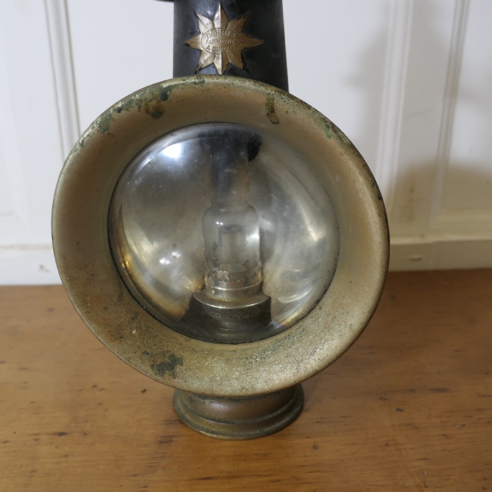 A pair of 19th-century French brass and iron carriage lamps with fluted chimney tops, brass star emblems, and circular convex glass lenses. View V