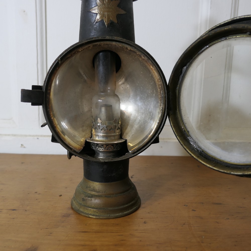 A pair of 19th-century French brass and iron carriage lamps with fluted chimney tops, brass star emblems, and circular convex glass lenses. View VII
