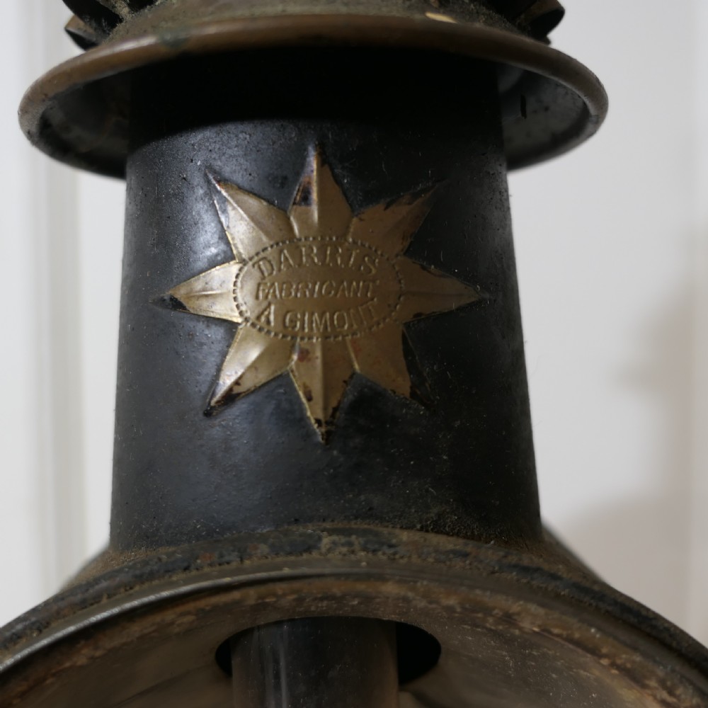 A pair of 19th-century French brass and iron carriage lamps with fluted chimney tops, brass star emblems, and circular convex glass lenses. View VIII