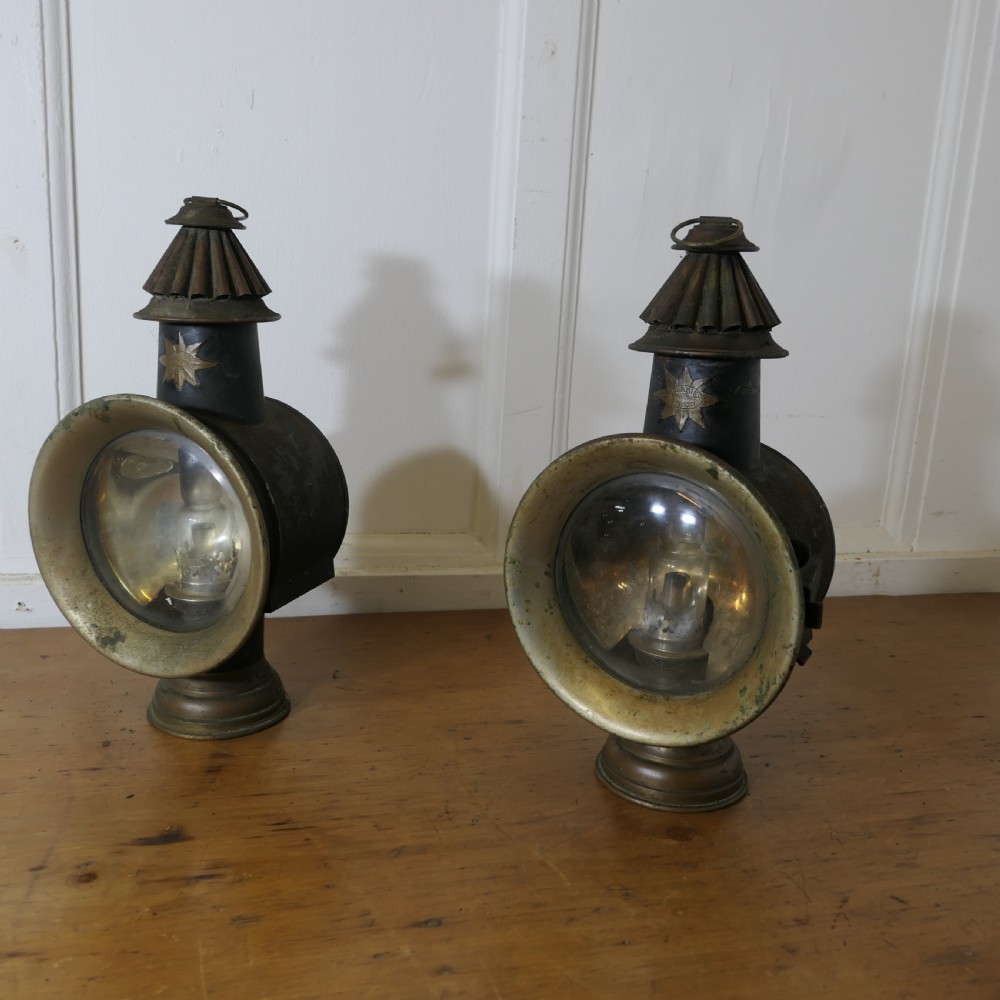 A pair of 19th-century French brass and iron carriage lamps with fluted chimney tops, brass star emblems, and circular convex glass lenses. View XIII