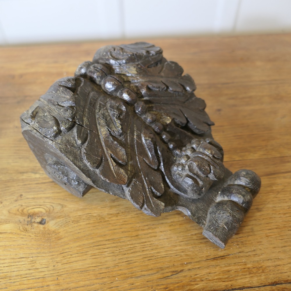 A pair of 17th-century dark oak wall brackets featuring deeply carved acanthus leaf motifs and scroll detailing. View II
