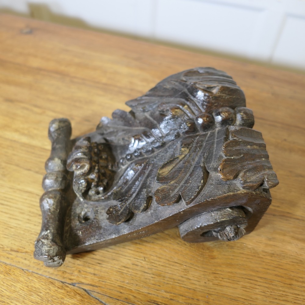 A pair of 17th-century dark oak wall brackets featuring deeply carved acanthus leaf motifs and scroll detailing. View III