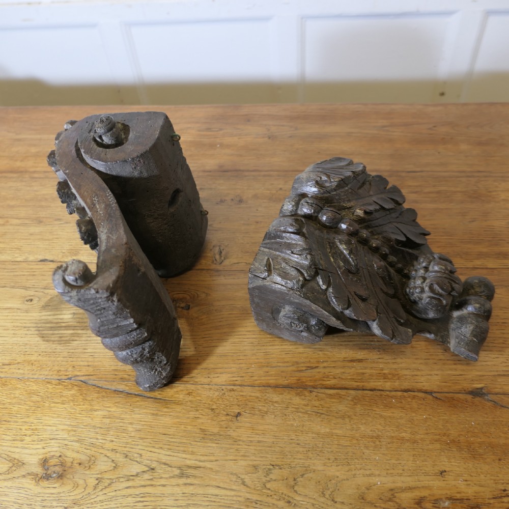 A pair of 17th-century dark oak wall brackets featuring deeply carved acanthus leaf motifs and scroll detailing. View IV