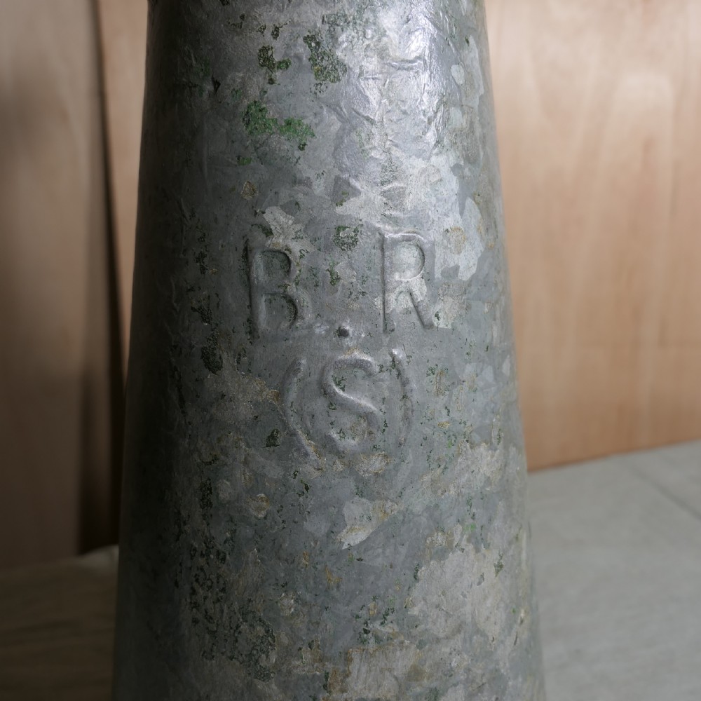 A tall conical galvanised metal water jug embossed with BR S featuring a side loop handle and a top hinged lid assembly. View VII