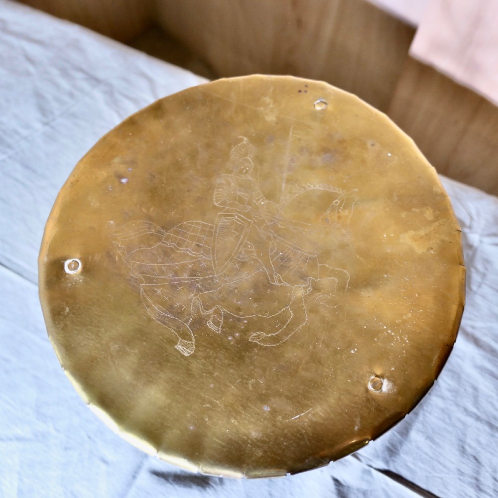 An antique brass and iron gypsy trivet featuring a scalloped brass top plate supported by crossed iron legs and a circular brass base. View V