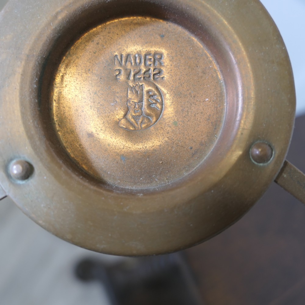 A vintage circular copper bain marie featuring a lid, long handle, and a three-legged brass tripod stand with an integrated burner tray. View IV