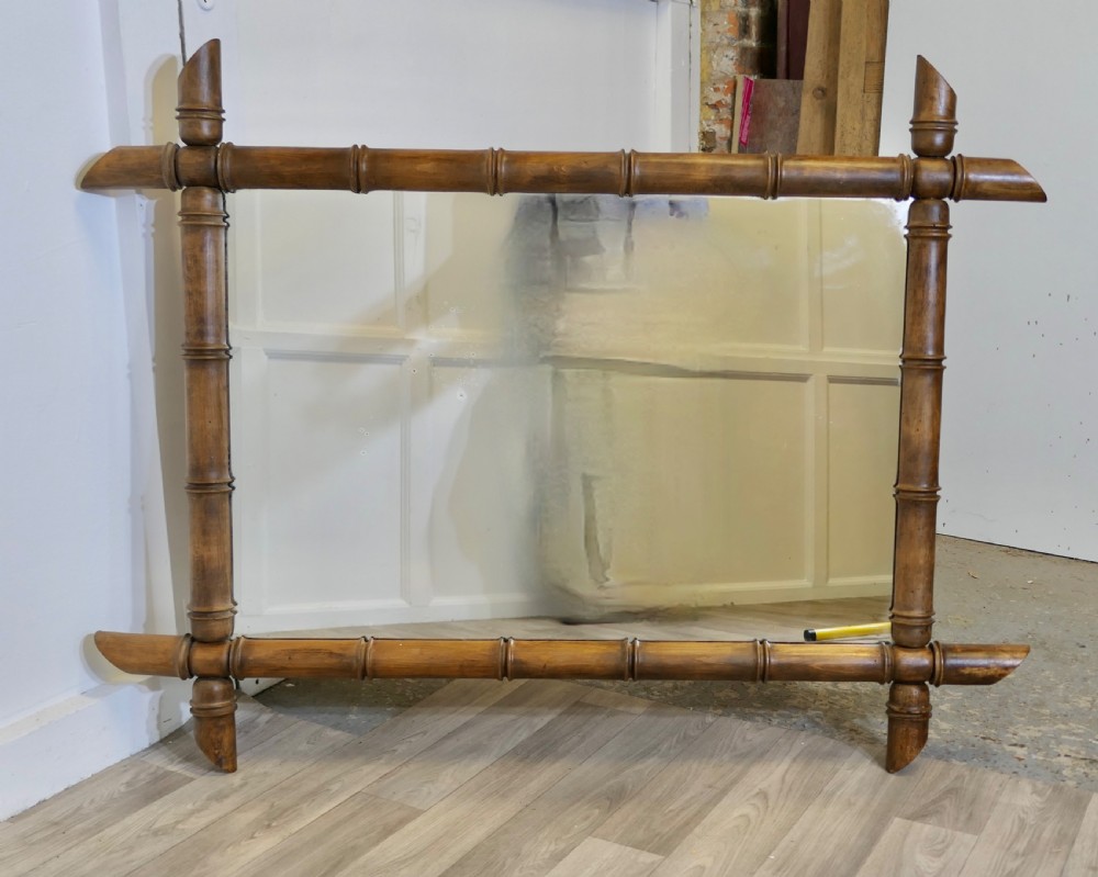 A rectangular wall mirror featuring a carved wooden frame styled to resemble jointed bamboo poles with protruding corner joints. View VI