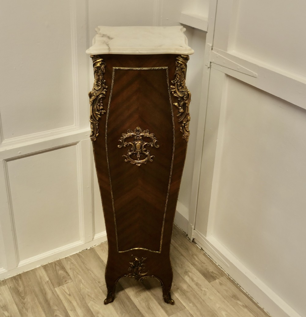 A tall French Rococo style walnut pedestal featuring a marble top, chevron wood veneer, and intricate gilt-bronze ormolu mounts. View II