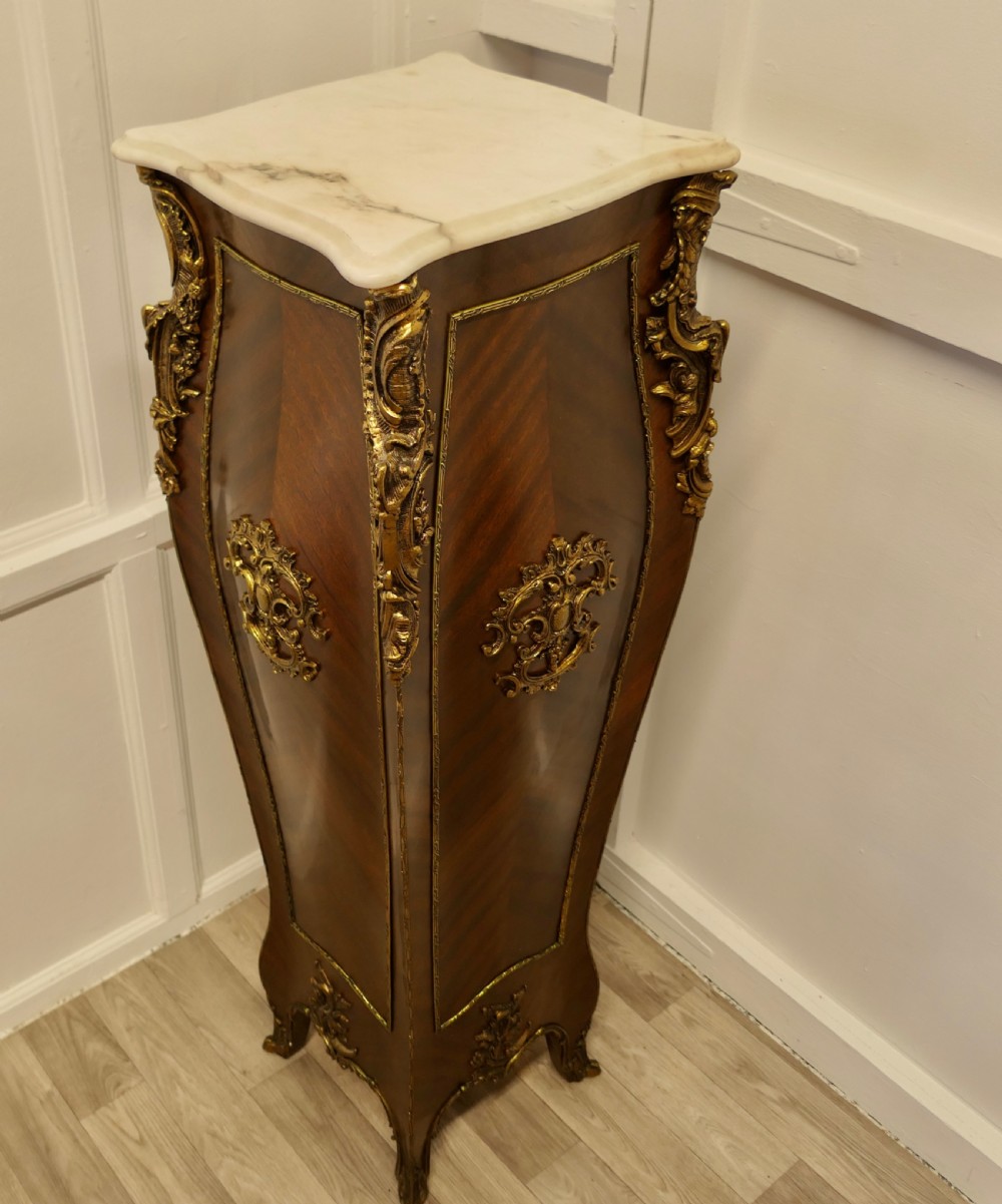A tall French Rococo style walnut pedestal featuring a marble top, chevron wood veneer, and intricate gilt-bronze ormolu mounts. View VI