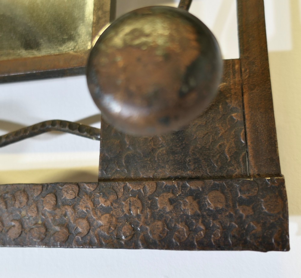 A French Art Deco dark wrought iron wall-mounted rack featuring a central rectangular mirror, top hat shelf, decorative scrollwork, and five coat pegs. View VI