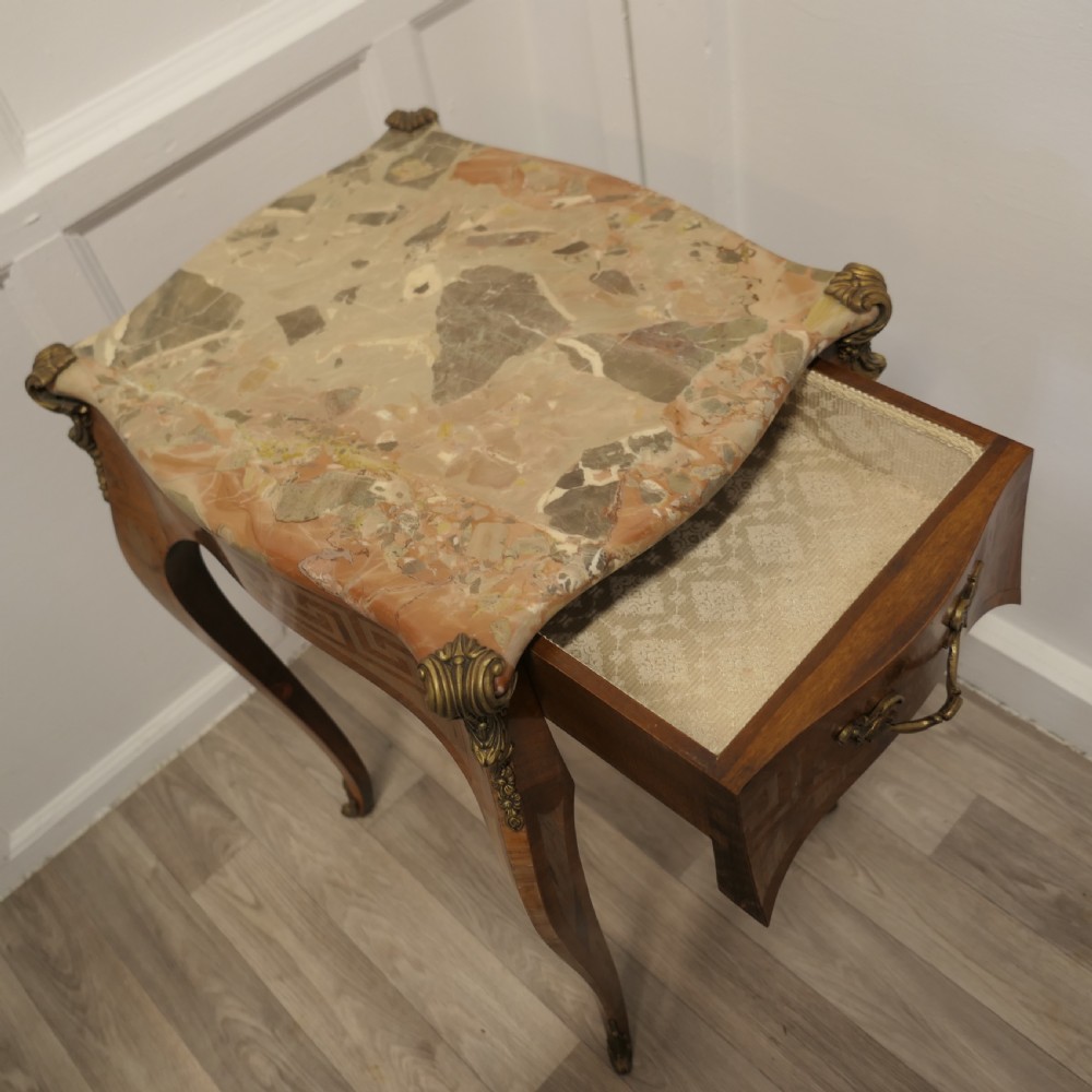 A French Louis XV style side table featuring a marble top, slender cabriole legs, parquetry wood inlay, and decorative ormolu mounts. View III