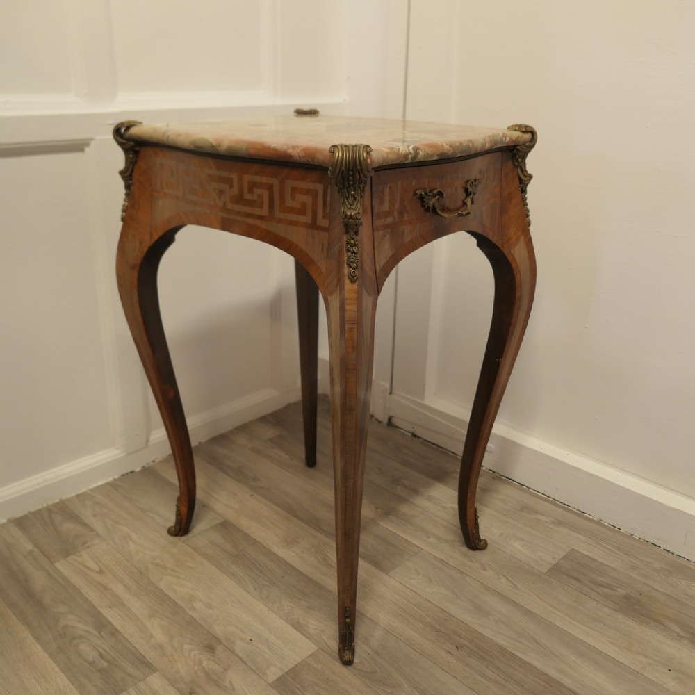 A French Louis XV style side table featuring a marble top, slender cabriole legs, parquetry wood inlay, and decorative ormolu mounts. View IV