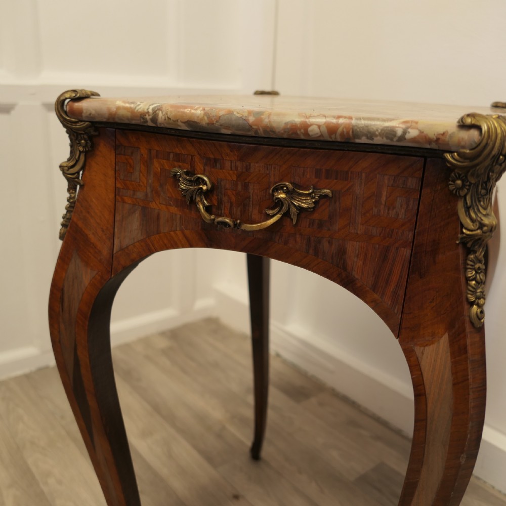 A French Louis XV style side table featuring a marble top, slender cabriole legs, parquetry wood inlay, and decorative ormolu mounts. View VIII