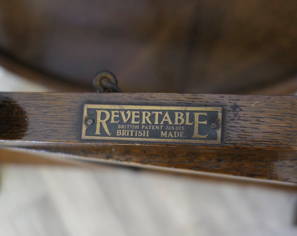 An antique dark oak folding coaching table featuring a circular top mounted on a hinged timber frame. View III