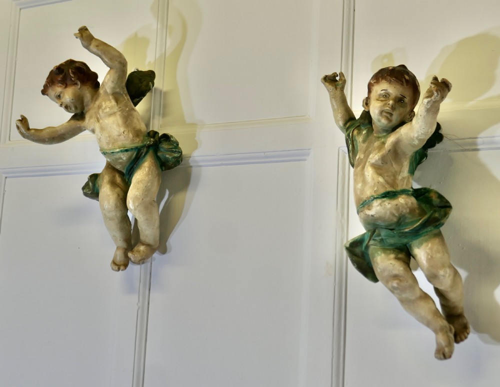 A pair of 19th-century Italian carved wood putti featuring painted dynamic poses and green drapery. View II