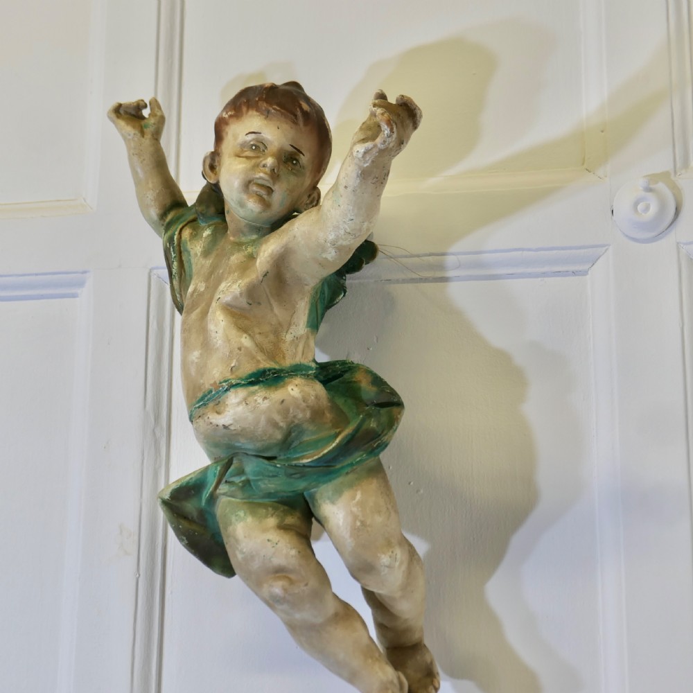 A pair of 19th-century Italian carved wood putti featuring painted dynamic poses and green drapery. View III
