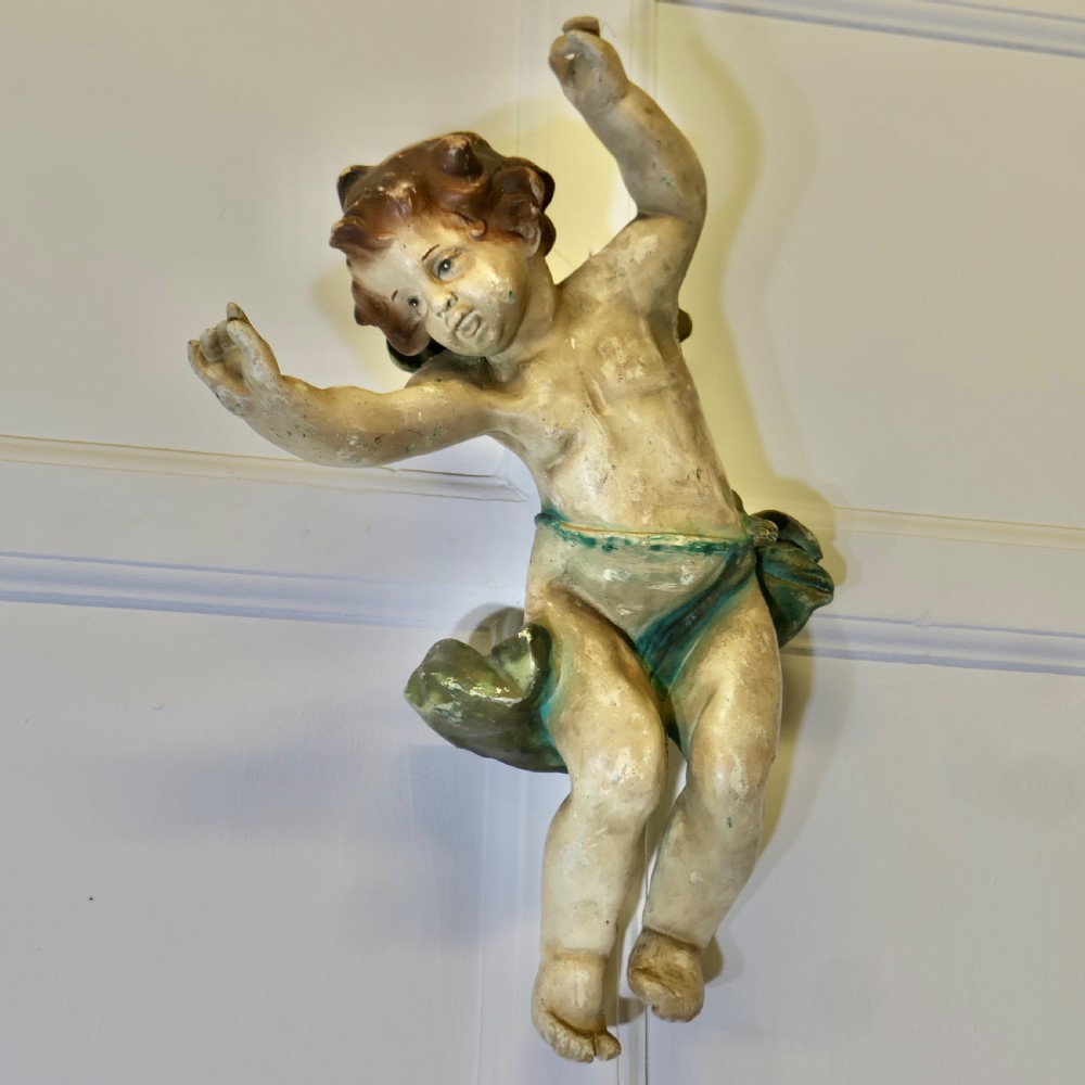A pair of 19th-century Italian carved wood putti featuring painted dynamic poses and green drapery. View VI