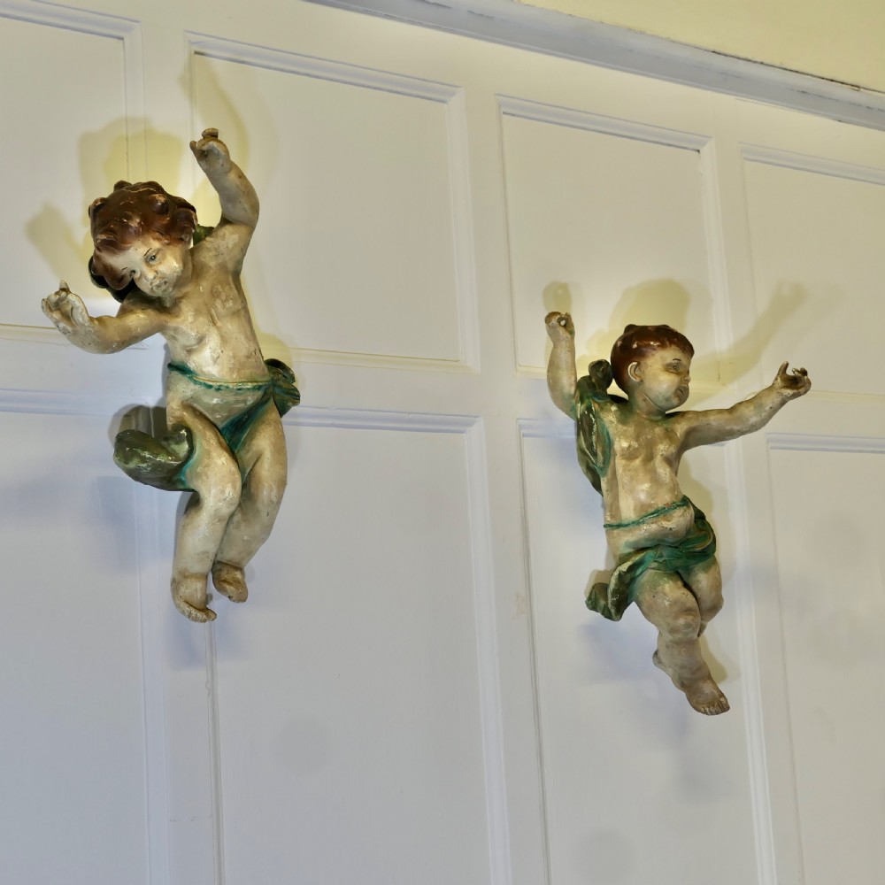 A pair of 19th-century Italian carved wood putti featuring painted dynamic poses and green drapery. View VII