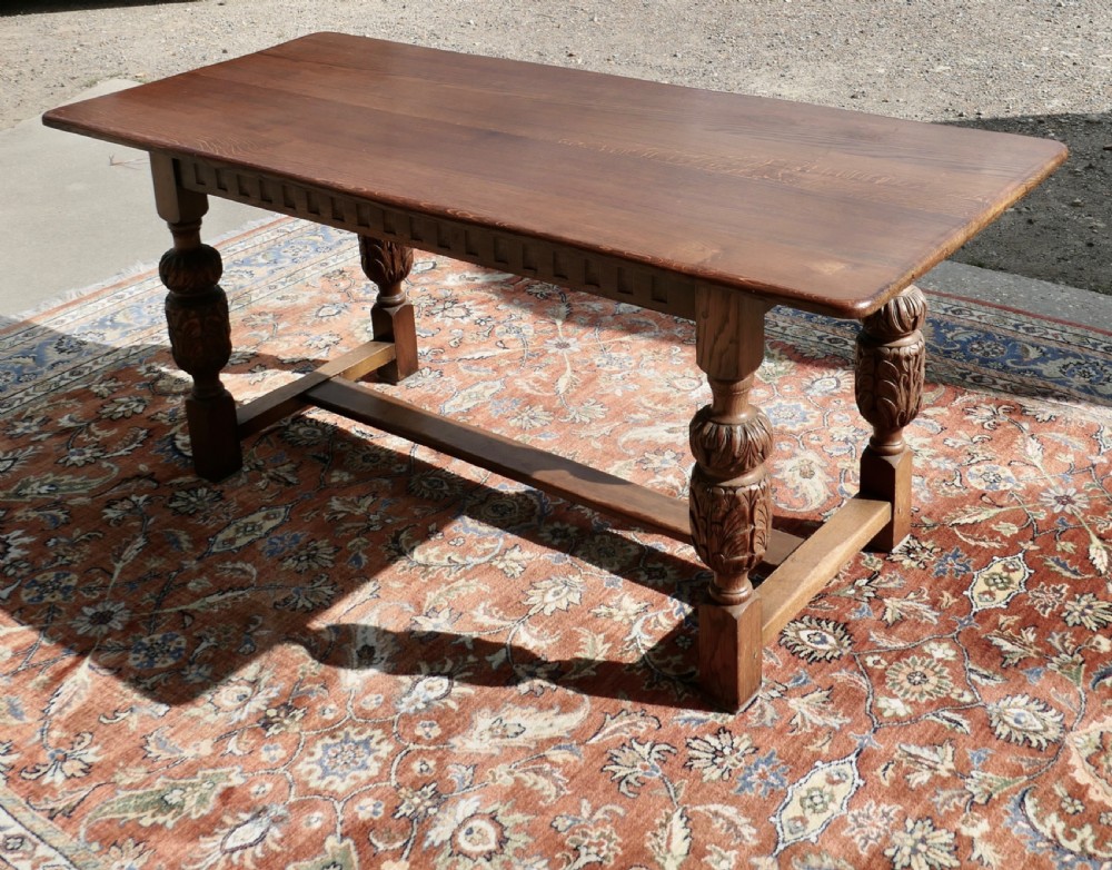 A rectangular solid oak refectory dining table featuring carved bulbous turned legs joined by a low central stretcher. View II