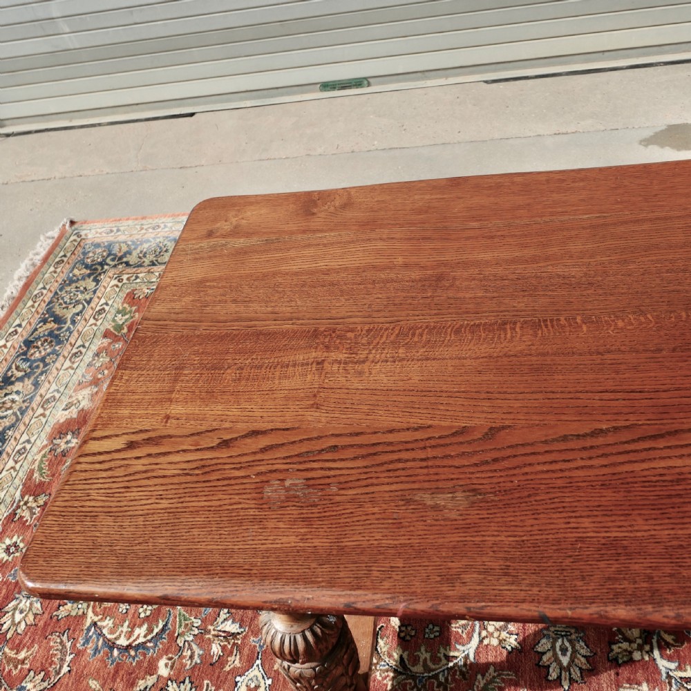 A rectangular solid oak refectory dining table featuring carved bulbous turned legs joined by a low central stretcher. View VIII