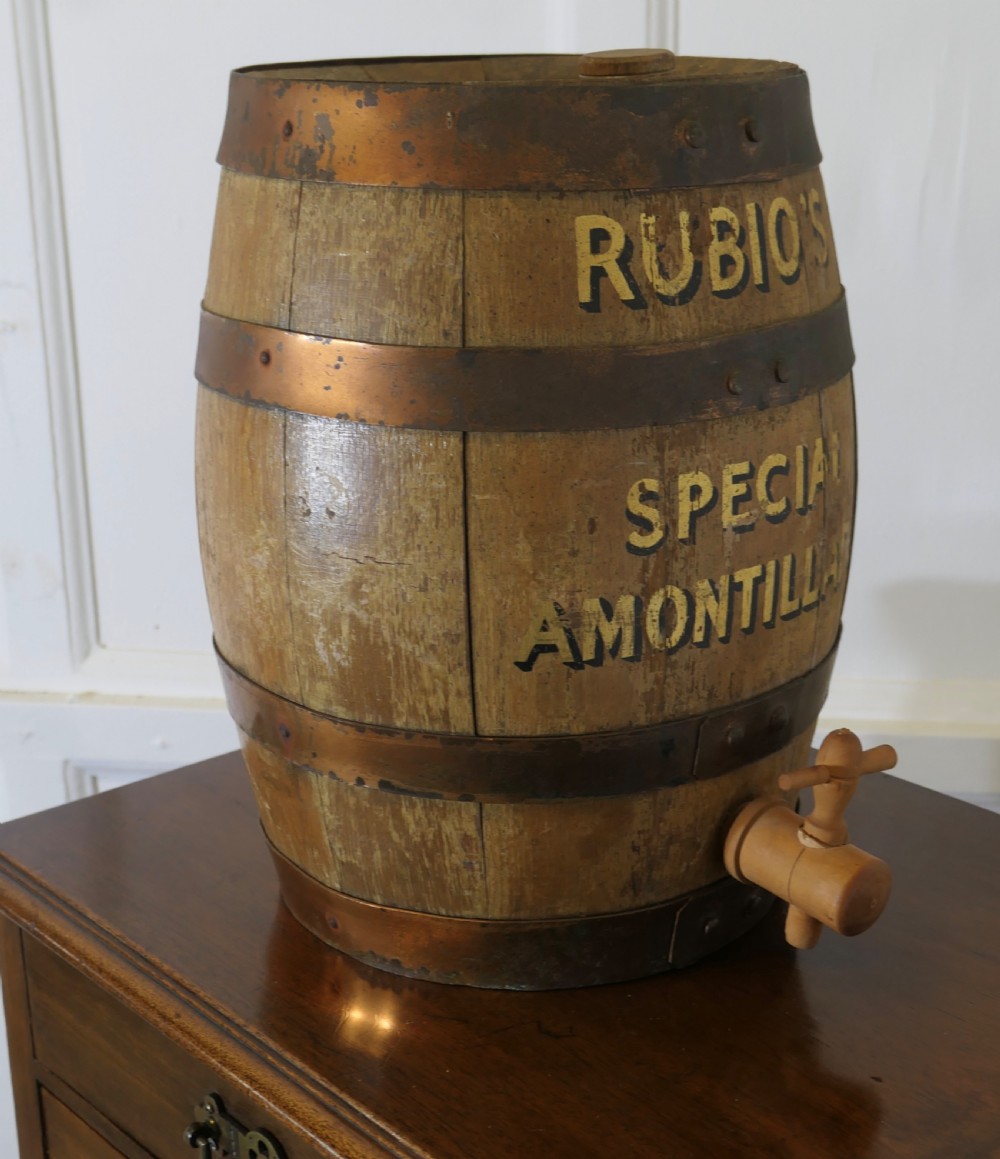A small oak sherry barrel featuring stencilled text reading RUBIOS SPECIAL AMONTILLADO with metal hoops and a wooden tap. View IV