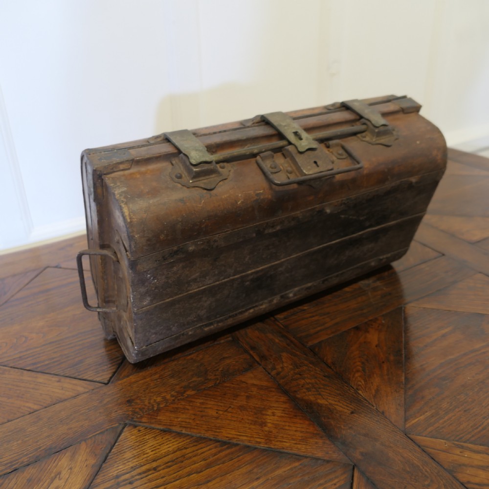 An antique patinated steel travel trunk featuring riveted metal edges, brass latches, and stencilled lettering reading Best Steel. View III