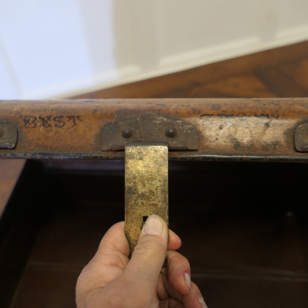 An antique patinated steel travel trunk featuring riveted metal edges, brass latches, and stencilled lettering reading Best Steel. View VII