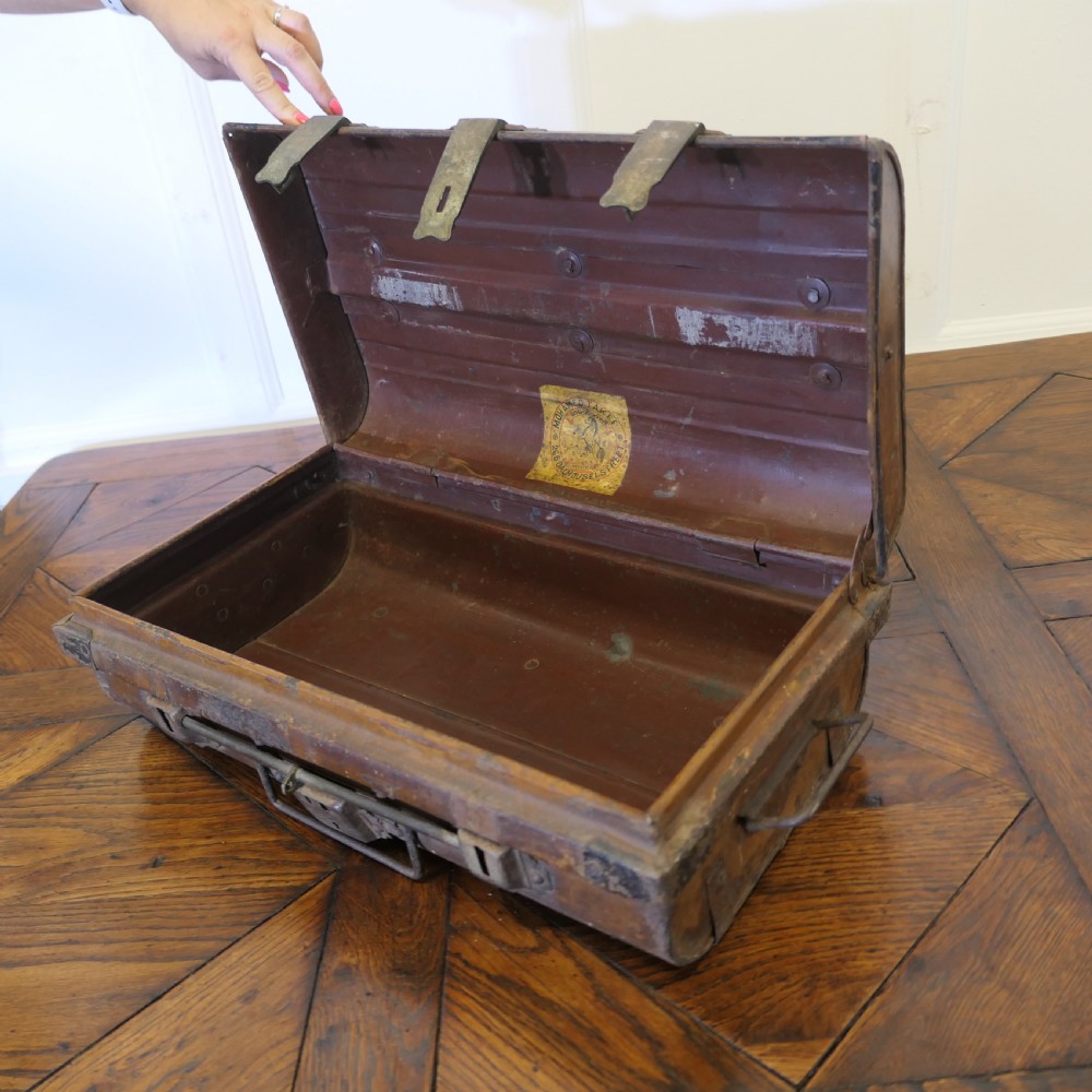 An antique patinated steel travel trunk featuring riveted metal edges, brass latches, and stencilled lettering reading Best Steel. View VIII