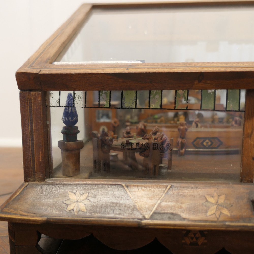 An early 20th-century wooden diorama display case featuring a miniature scene of a monkey saloon titled Bills Bar. View IV