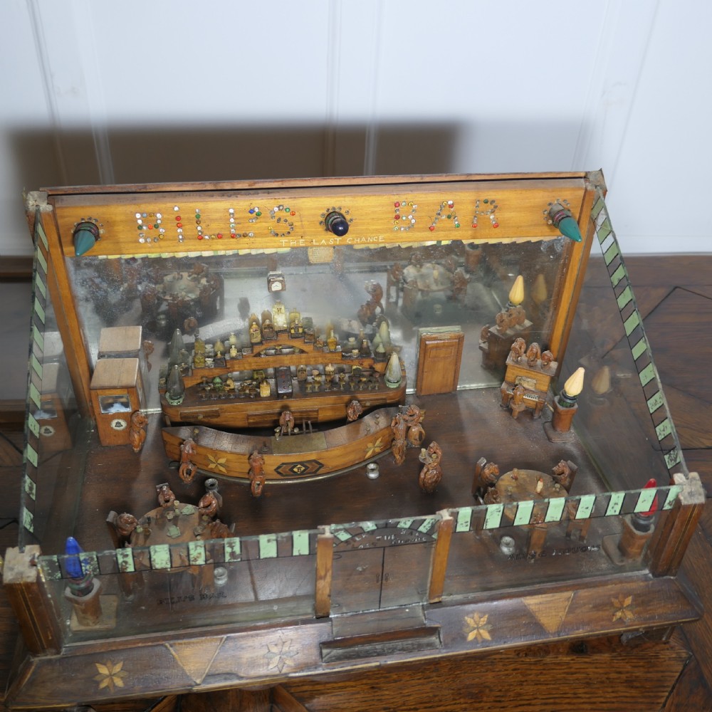 An early 20th-century wooden diorama display case featuring a miniature scene of a monkey saloon titled Bills Bar. View IX