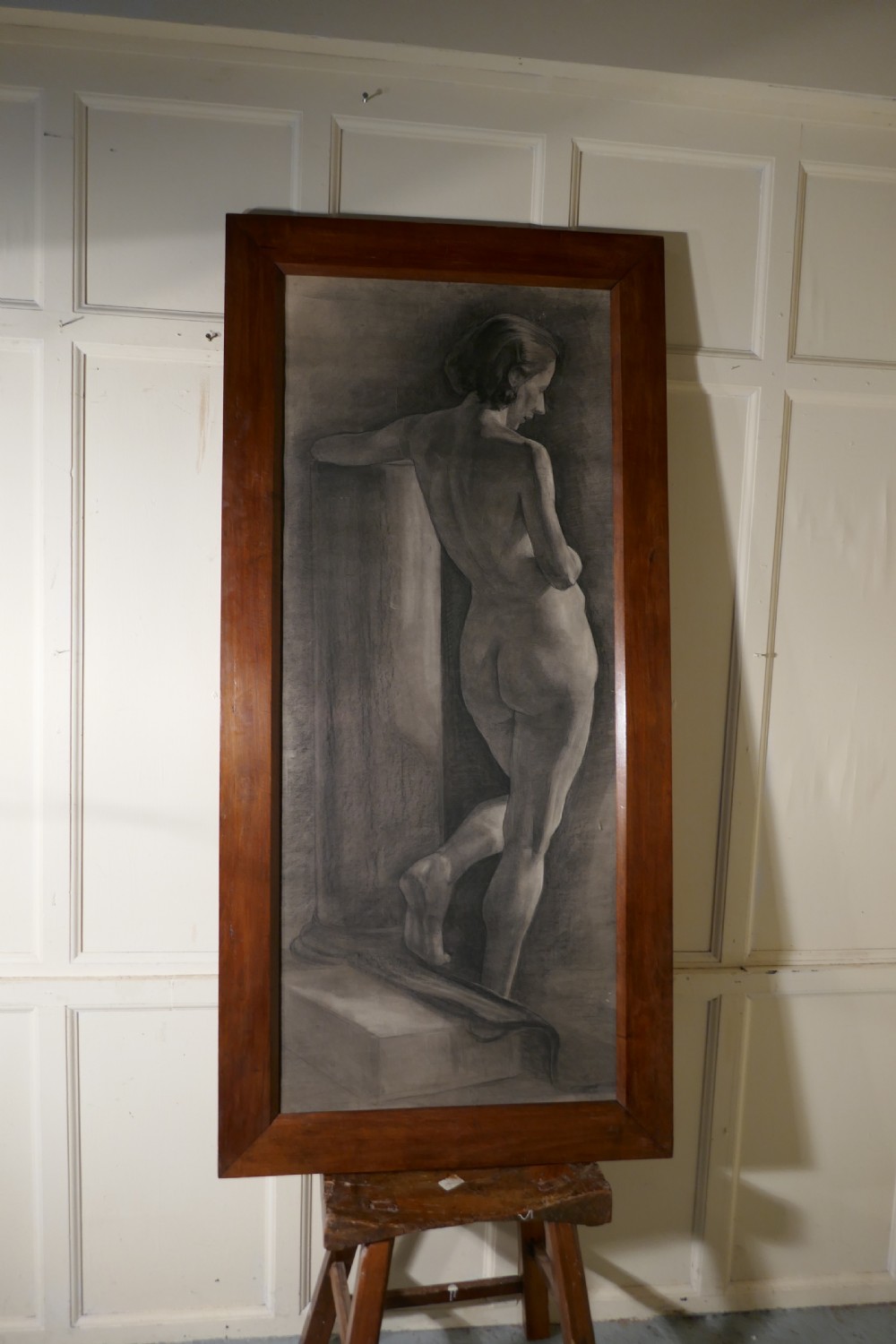 A full-length charcoal study of a standing female nude in profile and back view, set within a polished timber frame. View III