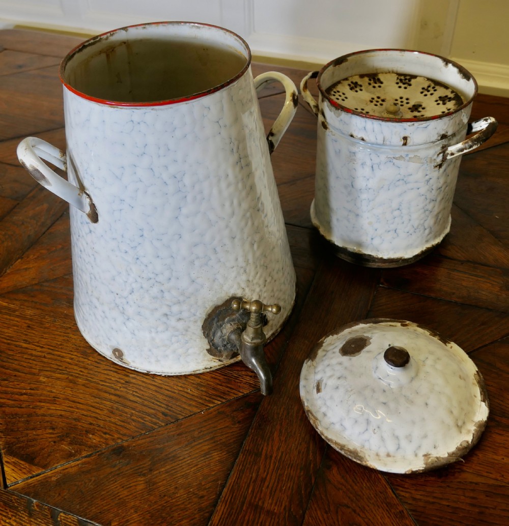 A tall antique white and blue marbled enamel coffee urn featuring a brass tap near the base, loop side handles, and red trim along the rim. View V