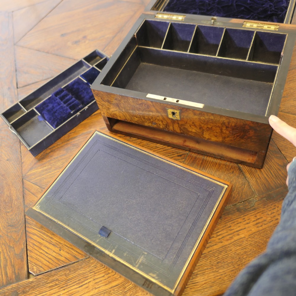 A set of three polished antique burr walnut storage boxes featuring brass keyhole escutcheons resting on a parquet floor. View VI