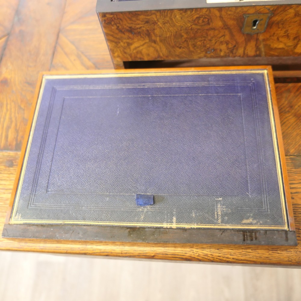 A set of three polished antique burr walnut storage boxes featuring brass keyhole escutcheons resting on a parquet floor. View XI