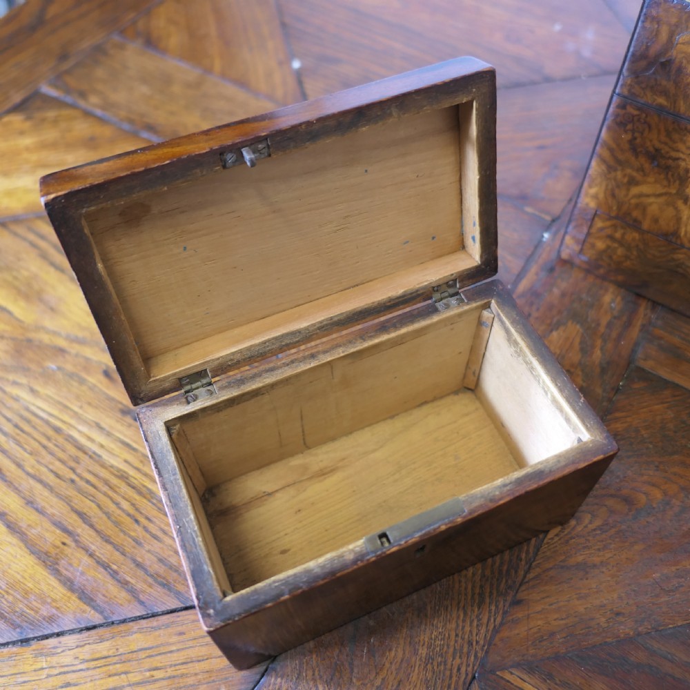 A set of three polished antique burr walnut storage boxes featuring brass keyhole escutcheons resting on a parquet floor. View XIV