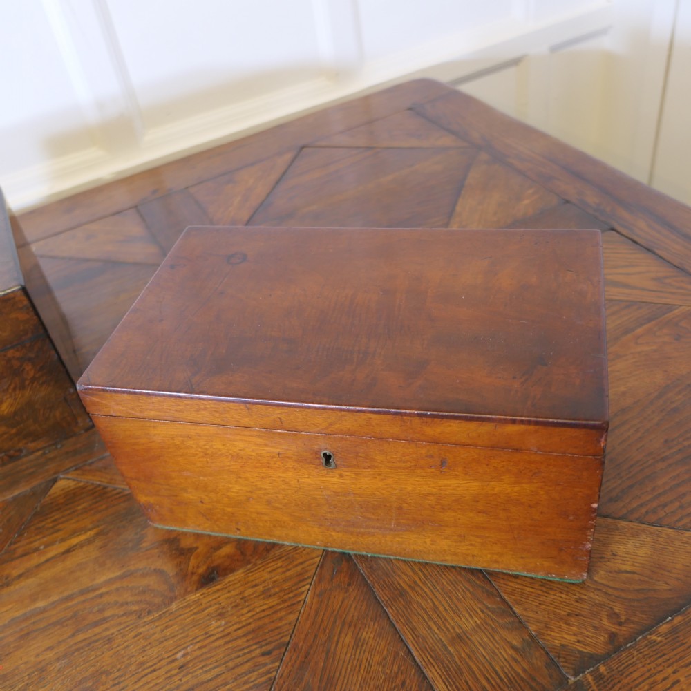 A set of three polished antique burr walnut storage boxes featuring brass keyhole escutcheons resting on a parquet floor. View XVI