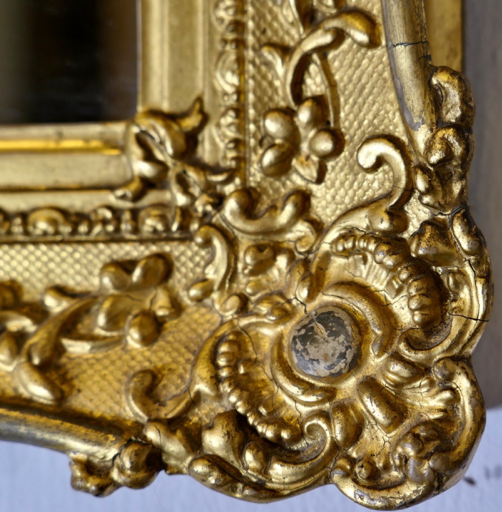A nineteenth-century French rectangular wall mirror featuring an ornate giltwood frame with floral mouldings and a textured cross-hatched ground. View VI