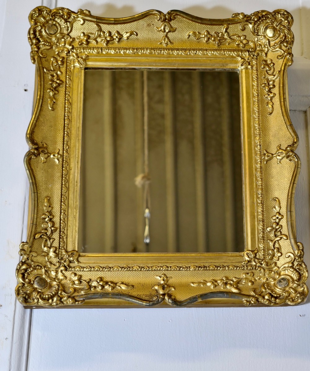 A nineteenth-century French rectangular wall mirror featuring an ornate giltwood frame with floral mouldings and a textured cross-hatched ground. View VII