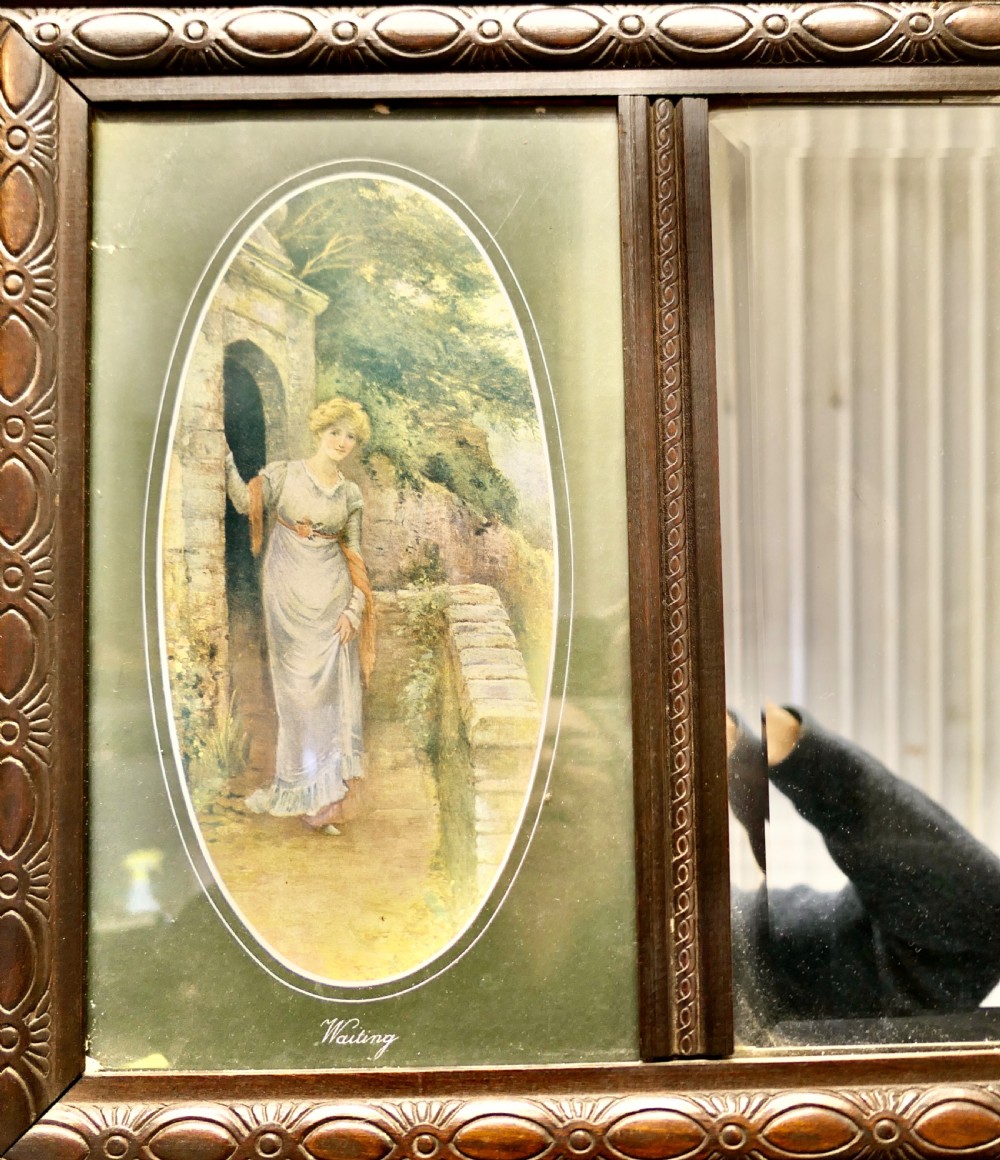 An Edwardian dark wood rectangular frame featuring a central rectangular mirror flanked by two oval colour prints depicting romantic figures. View III