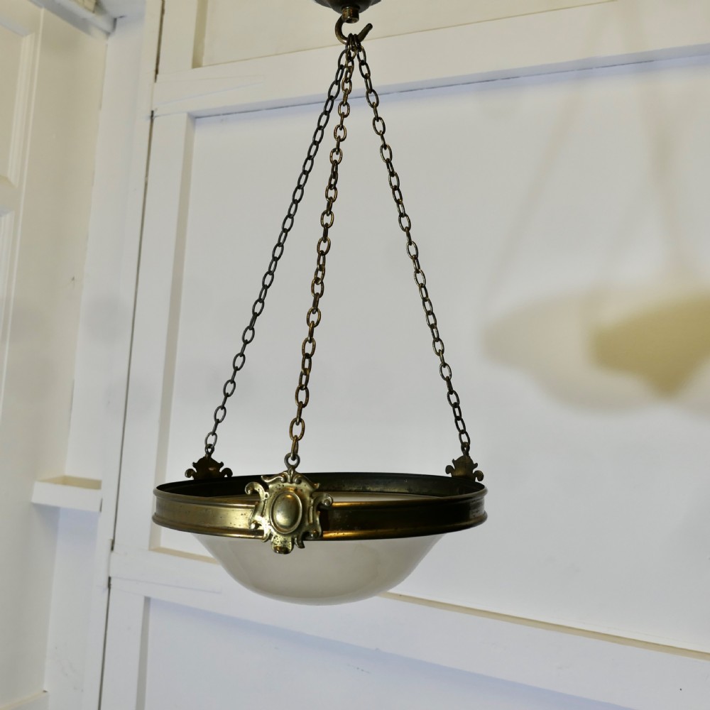 An antique Arts and Crafts ceiling light featuring a bowl-shaped opalescent glass shade suspended by three brass chains attached to a brass collar and ceiling rose. View II