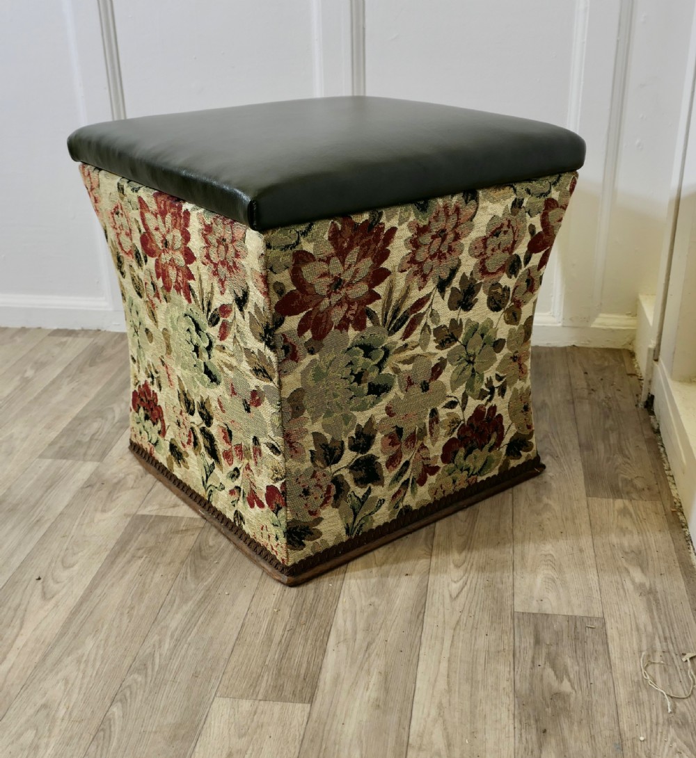 A waisted upholstered ottoman featuring a dark green leather seat above floral woven tapestry sides. View III