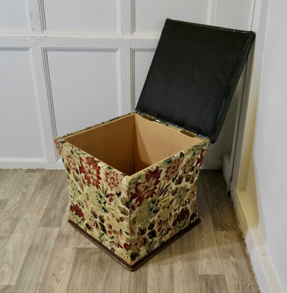 A waisted upholstered ottoman featuring a dark green leather seat above floral woven tapestry sides. View IV