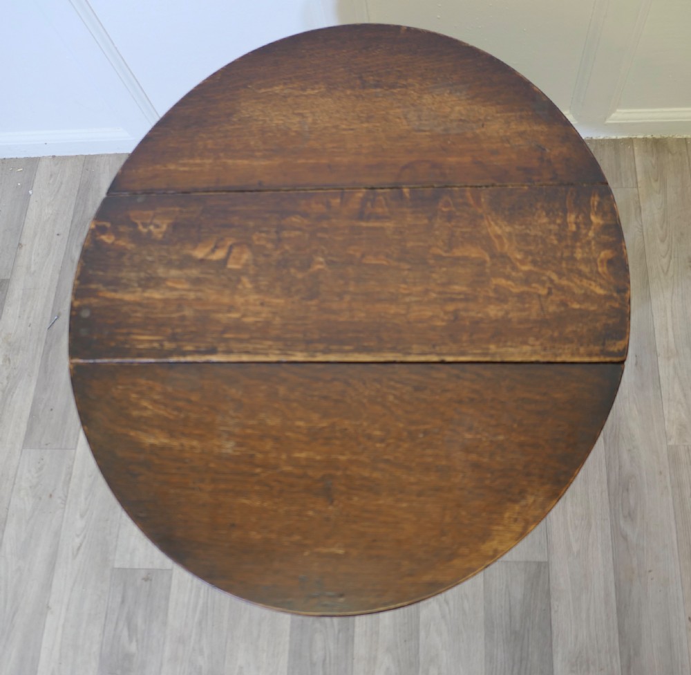 A dark oak low occasional coffee table with two drop-leaf flaps, turned bobbin legs, and a stretcher base. View IV