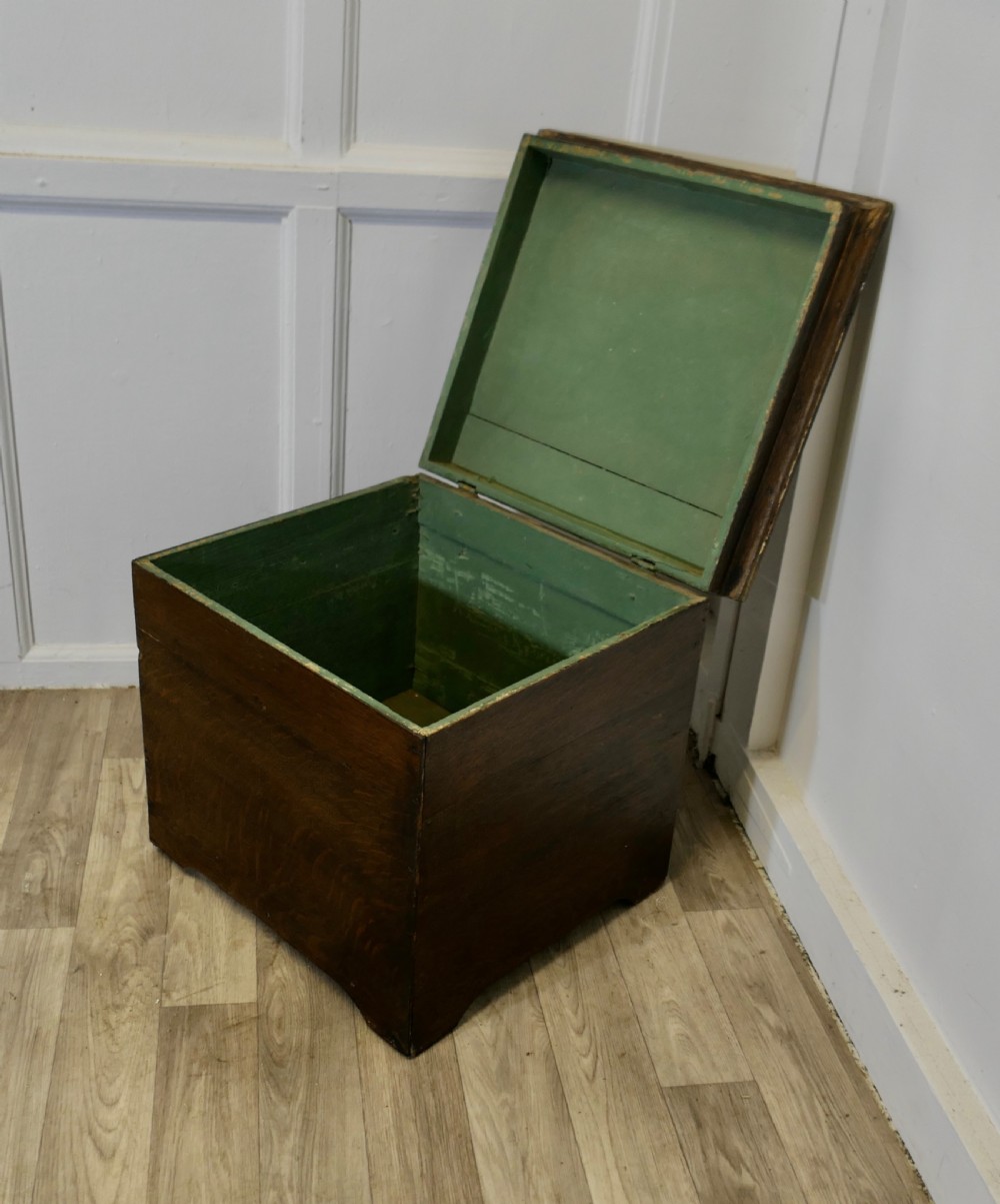 A dark oak square storage chest featuring a hinged lid open to reveal a green painted interior.