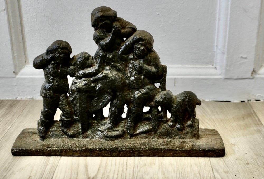 A 19th-century dark cast iron doorstop featuring a figurative narrative scene mounted on a flat rectangular plinth base.