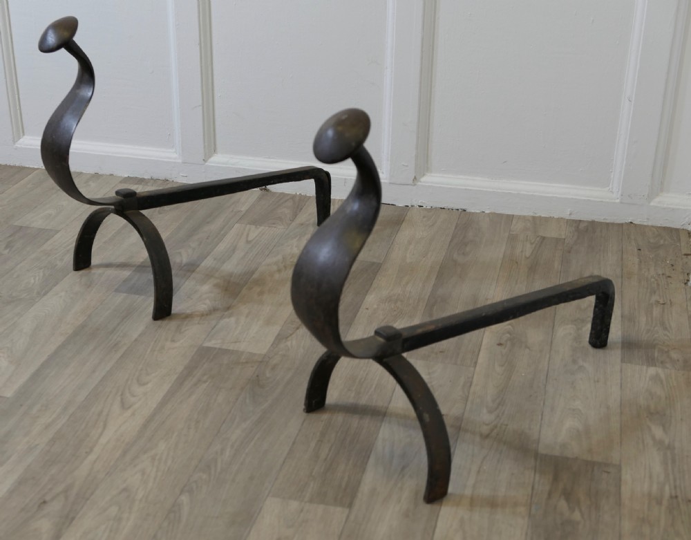A pair of dark wrought iron French Gothic fire dogs featuring arched legs, curved upright front plates, and disc finials. View III