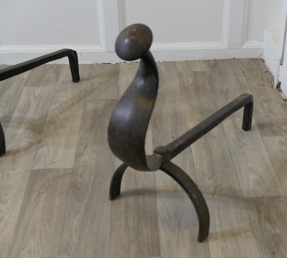A pair of dark wrought iron French Gothic fire dogs featuring arched legs, curved upright front plates, and disc finials. View IV